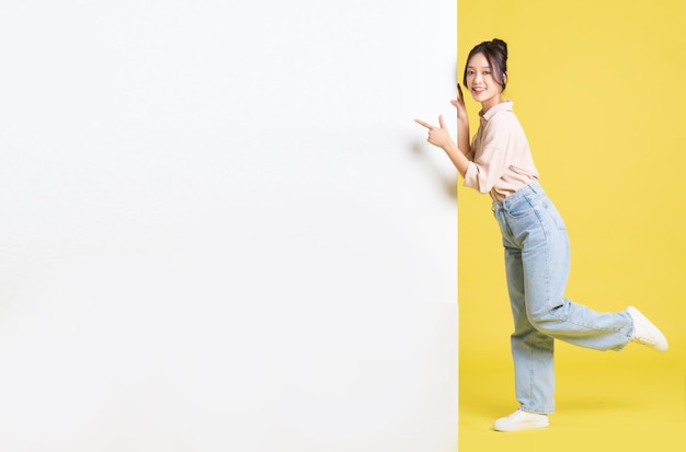 Image of Asian girl standing and posing with billboard