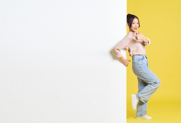 Image of Asian girl standing and posing with billboard