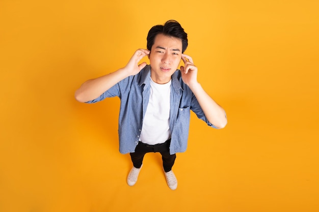 Image of asian man posing on a yellow background