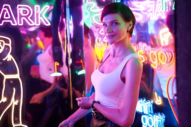 Image of a beautiful girl in an amusement park in a room with neon light Entertainment concept