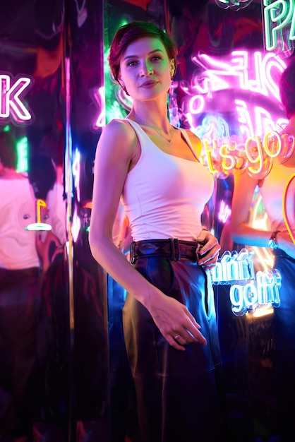 Image of a beautiful girl in an amusement park in a room with neon light Entertainment concept