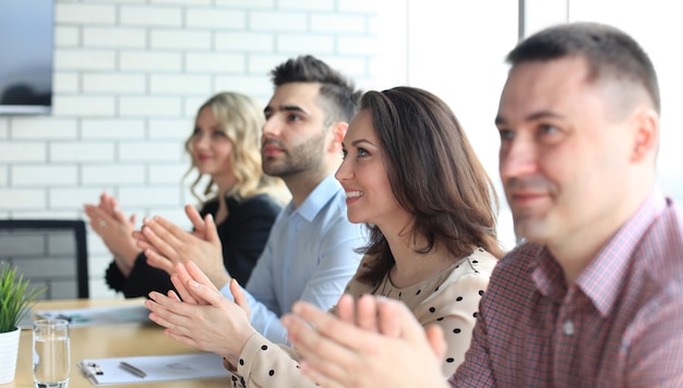 Image of business colleagues applauding in the end of the conference sitting in a line