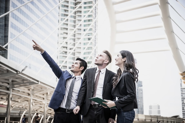 Image of business partners discussing documents and ideas at meeting together outside