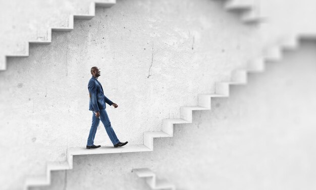 Image of businessman walking upstairs. Mixed media