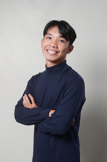 Image of cheerful asian man smiling and looking at camera