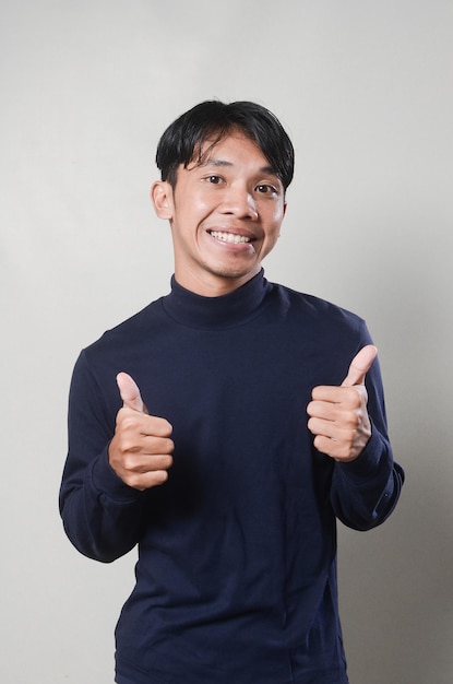 Image of cheerful asian man smiling and looking at camera