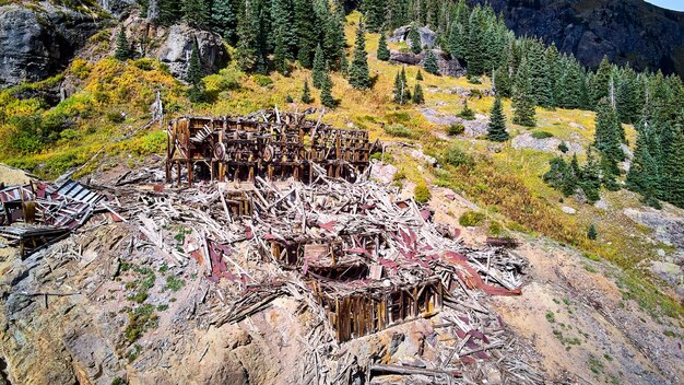 Image of Close aerial view of old mining mill structure abandoned and falling apart in mountains