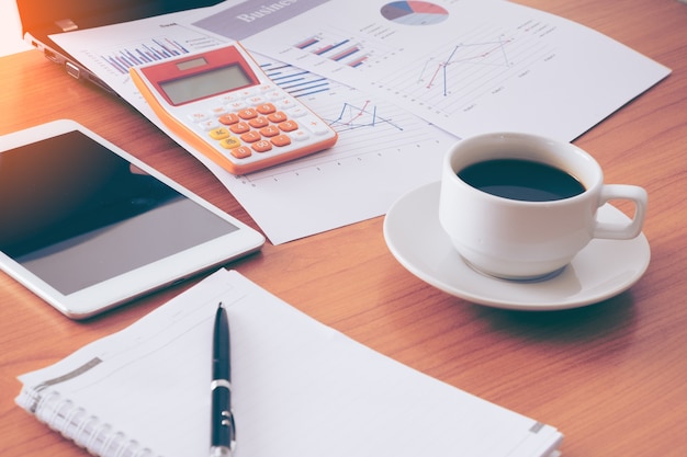 Image of coffee on desk of working businesspeople at meeting