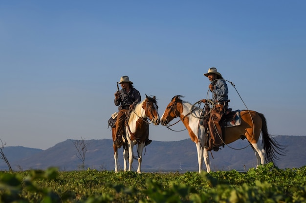 The image of the cowboy action is riding a horse and holding a gun in his hand.