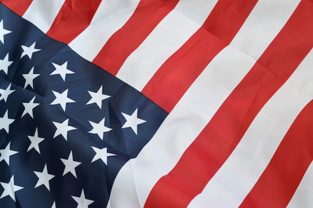 Image of a crumpled American flag with many folds waving in the wind