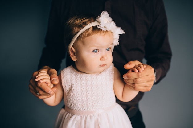 Image of cute little daughter in young dad's hands