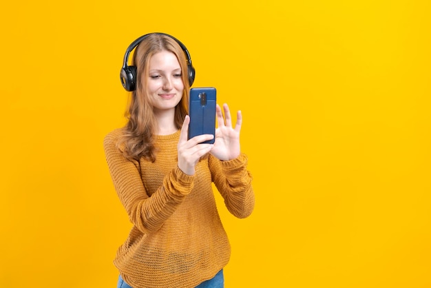 Image of emotional happy excited young woman listening to music with headphones