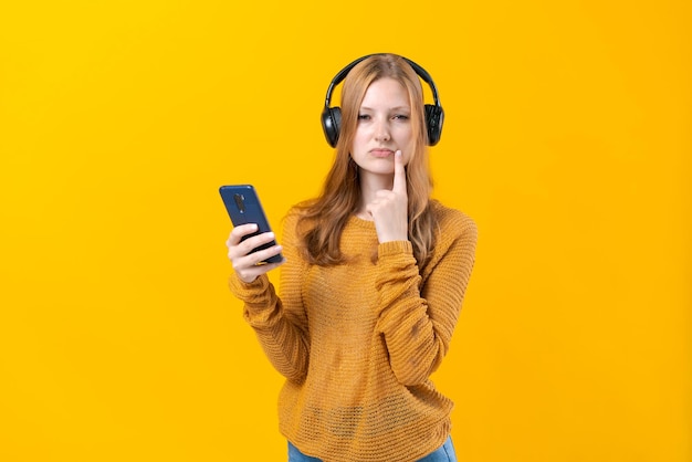 Image of emotional happy excited young woman listening to music with headphones