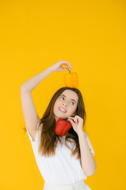 Image of emotional positive young beautiful woman posing and holding paprika