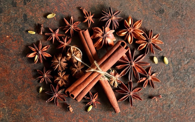 An image of a festive arrangement of holiday spices including cinnamon sticks and cloves