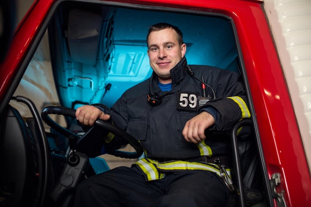 Image of fireman man sitting in cab of fire truck