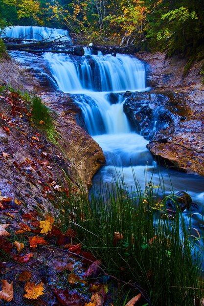 Image of Four-tiered waterfall with fall leaves against the cliff walls