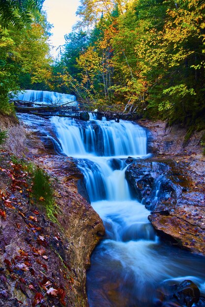 Image of Four-tiered waterfall with smooth flowing white water and nearly baren cliffs surrounding it