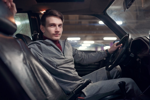 Image from side of man looking at camera sitting in car