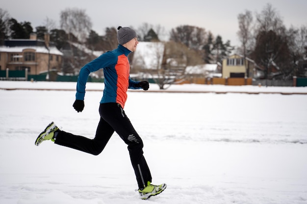 Image from side of man in sportswear gray cap on run