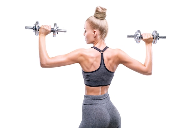 Image of a girl with dumbbells in her hands in a white studio Fitness and bodybuilding concept Back view