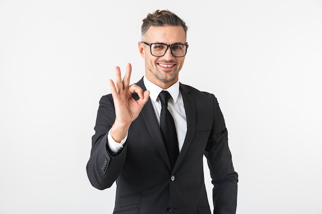 Image of a handsome business man isolated over white wall posing showing okay gesture.