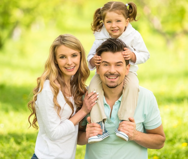 Image of happy young family walking in park.