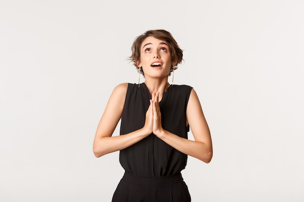 Image of hopeful praying girl clasp hands together and looking up