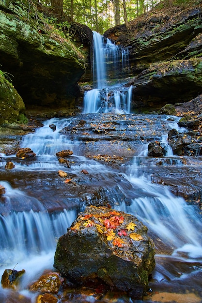 Image of Horseshoe falls waterfall with giant bolder covered in red yellow and orange fallen leaves