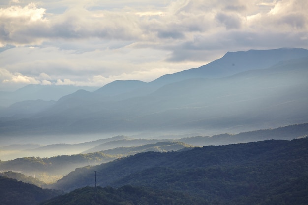 Image of Landscape of the Smokey Mountains with haze between the peaks on an overcast day with one large mountain looming in the background