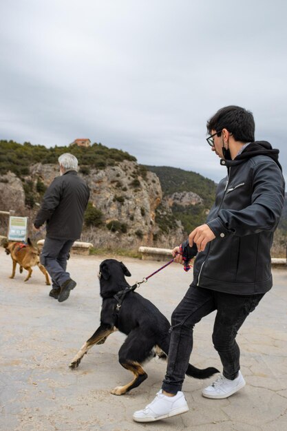 Image of a man holding his mad dog trying to face another dog the importance of the safety of taking your dog on a leash