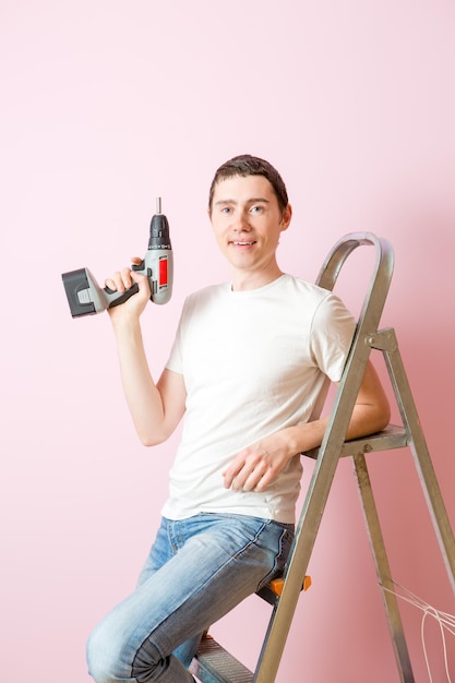 Image of man with drill near ladders