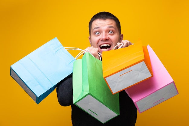 Image of man with shopping bags on orange background