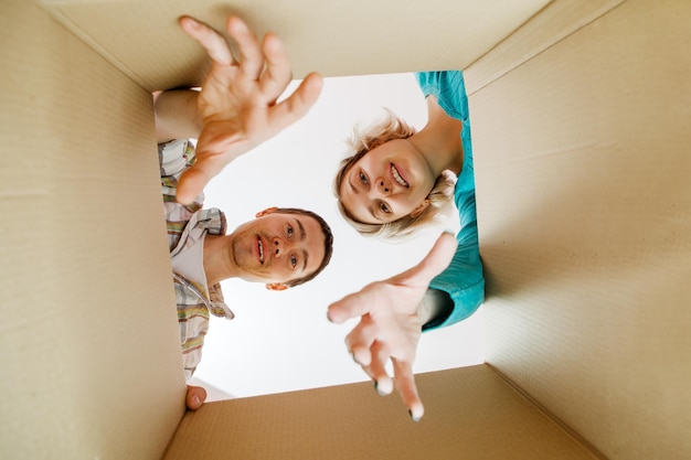 Image of man and woman peering into cardboard box