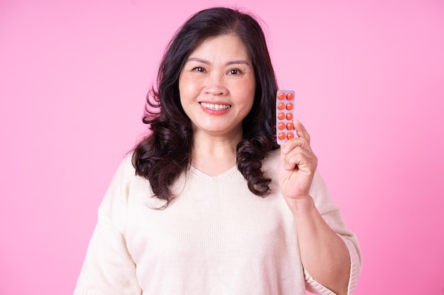 Image of middle aged Asian woman on pink background