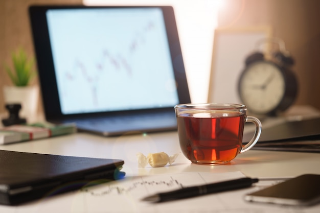 An image of a morning, office desk of a financial analyst close-up.