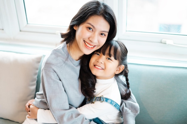 Image of mother and daughter cuddling on the sofa