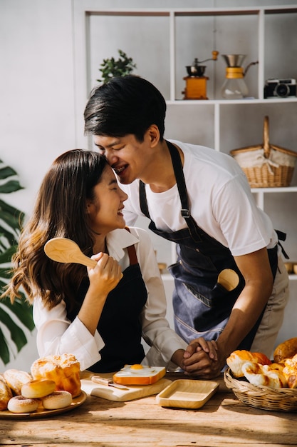 Image of newlywed couple cooking at home Asia young couple cooking together with Bread and fruit in cozy kitchen in home