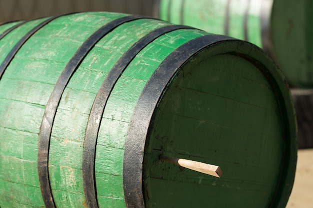 Photo image of an old oak wine barrel on the background of a rural courtyard.