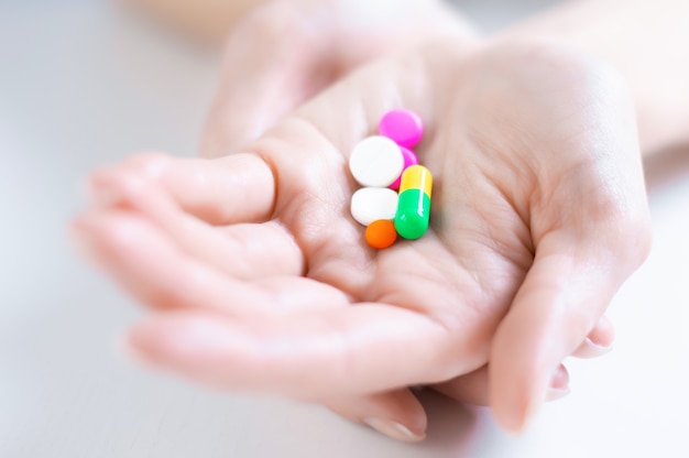 Image of pills on a female palm. The concept of medicine, health care, vitamins. Mixed media