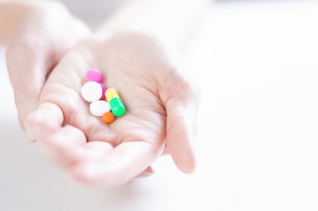 Image of pills on a female palm. The concept of medicine, health care, vitamins. Mixed media