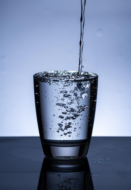 The image of pouring drinking water into a glass