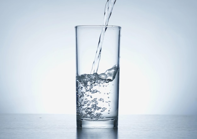 Image of pouring water from a water bottle into a glass