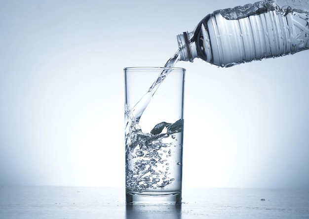 Image of pouring water from a water bottle into a glass