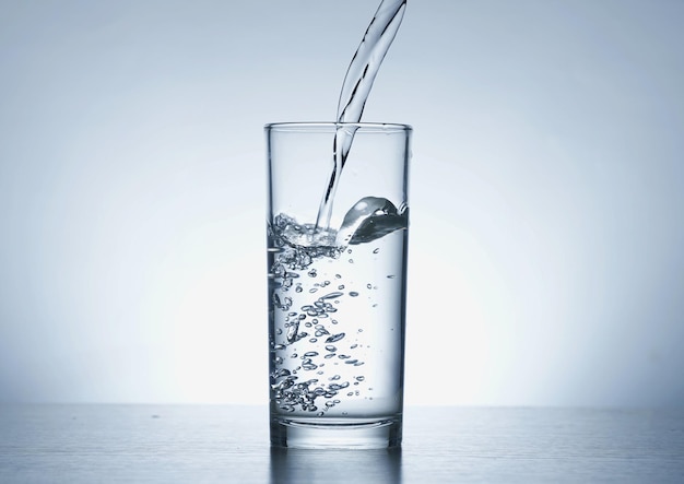 Image of pouring water from a water bottle into a glass