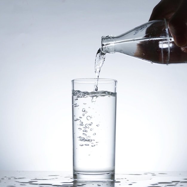 Image of pouring water from a water bottle into a glass