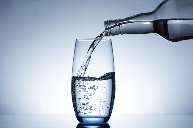 Image of pouring water from a water bottle into a glass