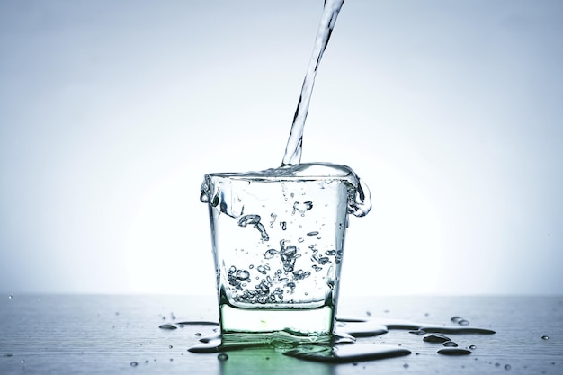 Image of pouring water from a water bottle into a glass