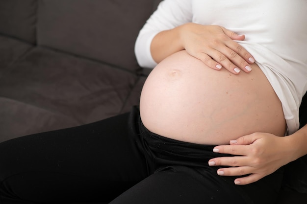 Image of pregnant woman touching her belly with hands