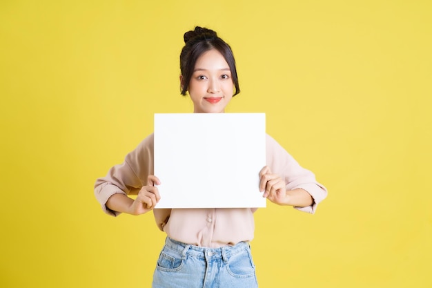 Image of a pretty asian girl holding a white billboard